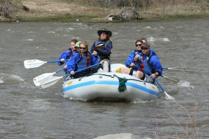 a group of people riding on the back of a boat in the water